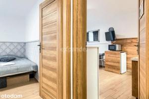 une porte menant à une chambre avec un lit dans l'établissement LUKSUSOWY Gaj Apartament, à Wrocław