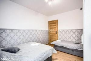 sypialnia z 2 łóżkami i drewnianą podłogą w obiekcie LUKSUSOWY Gaj Apartament we Wrocławiu
