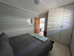 a bedroom with a bed and a large cabinet at 1One1@Boneyard in Jeffreys Bay