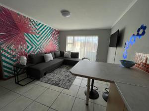 a living room with a couch and a table at 1One1@Boneyard in Jeffreys Bay