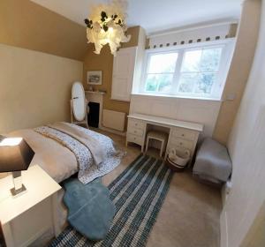 a bedroom with a bed and a desk and a window at JESMOND House B&B room 4 in Hull