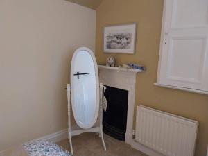 - un miroir blanc dans une pièce avec cheminée dans l'établissement JESMOND House B&B room 4, à Hull