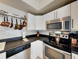 a kitchen with white cabinets and stainless steel appliances at La Favorita in Navarre