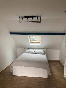 a bedroom with a white bed and a window at chez nanou&bibou in Auvers-sur-Oise