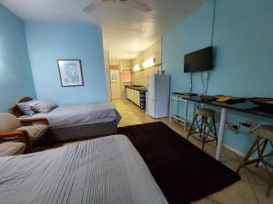 Habitación con 2 camas y cocina con nevera. en Ocean Breeze, en Warner Beach