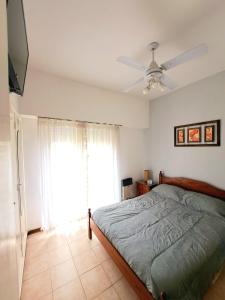 a bedroom with a bed and a ceiling fan at Luminoso, solo para familias in Mar del Plata