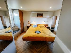 a small room with two beds and a mirror at De Strandhoed Renesse - Zee & Strand & Centrum in Renesse