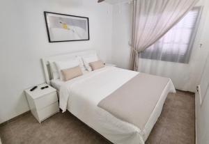 Un dormitorio blanco con una cama blanca y una ventana. en Apartamento Brisas del Mar, en San Miguel de Abona