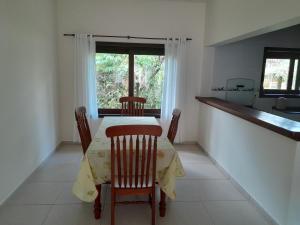 a dining room with a table and chairs and a window at Residencial Seestern - Suítes in Cananéia