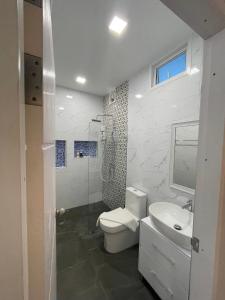 La salle de bains est pourvue de toilettes, d'un lavabo et d'une douche. dans l'établissement JB Grand Resort, à Nakhon Si Thammarat