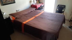 a bedroom with a large bed with a brown comforter at "Casa TOLIMA" in Barcelona