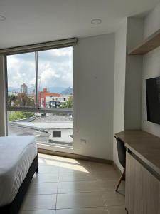 a bedroom with a bed and a large window at Apartamento de lujo Manizales in Manizales