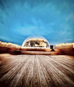 a glass domed building on top of a wooden deck at Hvítuborgir in Minni-Borg