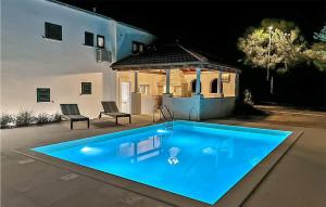 a large blue swimming pool in front of a house at Stunning Apartment In Zrnovo With Wifi in Žrnovo +30 photos