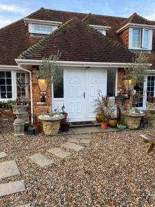 a house with a white door and some potted plants at Meadow View in Hurst