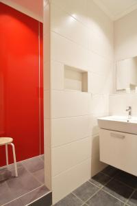 ein Badezimmer mit einem Waschbecken und einer roten Wand in der Unterkunft Hamburg App. 01 in Ahlbeck + 13 Fotos