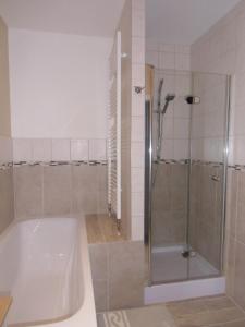 La salle de bains est pourvue d'une douche et d'une baignoire. dans l'établissement Udos Gästewohnung, à Cottbus