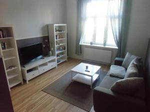 - un salon avec un canapé et une table dans l'établissement Udos Gästewohnung, à Cottbus