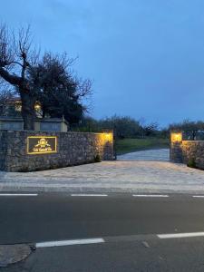 a stone fence with a sign on it next to a road at Villa Casina dell'Etna in Ragalna