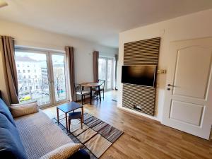 a living room with a couch and a flat screen tv at Open View City Apartment in Vienna