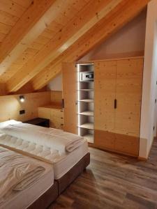 1 dormitorio con cama y techo de madera en Appartamento l’ Aier - Arabba - Dolomiti, en Livinallongo del Col di Lana