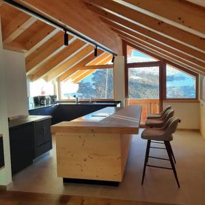 uma cozinha com uma grande ilha de madeira numa casa em Appartamento l’ Aier - Arabba - Dolomiti em Livinallongo del Col di Lana