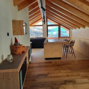 una cocina con armarios de madera y una mesa en una habitación en Appartamento l’ Aier - Arabba - Dolomiti, en Livinallongo del Col di Lana