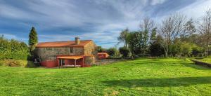 a brick building with a grassy yard next to a house at Casa Do Ghabino in Santa Comba