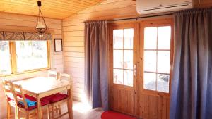 comedor con mesa y 2 ventanas en Stundarfriður cottages, en Stykkishólmur
