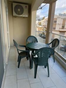 uma mesa verde e cadeiras numa varanda com uma ventoinha em Lovely 3-bedroom apartment in L-Iklin em Iklin
