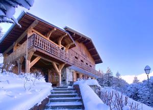 une cabane en rondins avec de la neige sur les escaliers dans l'établissement Chalet Miravidi, Montchavin-La Plagne, Jacuzzi & Sauna, à Montchavin