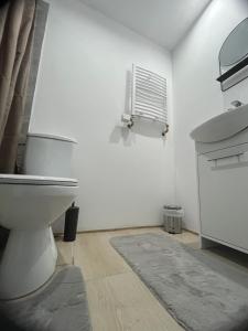 biała łazienka z toaletą i umywalką w obiekcie Tani Apartament Duszniki-Zdrój w mieście Duszniki Zdrój