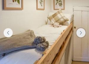 a wooden bed with two arrows in a bedroom at Inglenook Cottage, The Cotswolds in Winchcombe