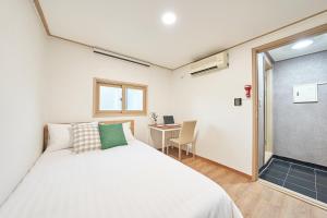 a bedroom with a white bed and a desk at K'STAY Sinchon in Seoul
