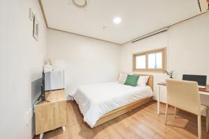 a small bedroom with a bed and a desk at K'STAY Sinchon in Seoul
