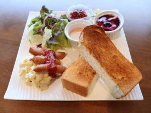a white plate of food with a sandwich and toast at APA Hotel Keikyukamata Ekimae in Tokyo