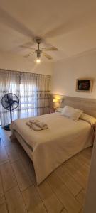 a bedroom with a large bed with a ceiling fan at Hotel Soleares in Mar del Plata