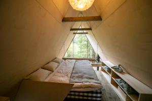 a bed in the middle of a room with a window at Hygge Chalet 