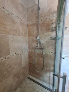 een badkamer met een douche en een glazen deur bij Superbe Appartement 3 pièces près de la Défense in Nanterre