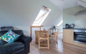 a living room with a couch and a table and a kitchen at The Chalet Somerset in Angersleigh