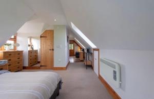 Angersleigh的住宿－The Chalet Somerset，一间带两张床的卧室和一个带楼梯的走廊