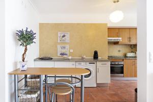 cocina con mesa, mesa y sillas en Lavender Apartment en Santa Luzia
