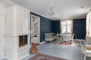 een woonkamer met een open haard en een tafel bij Maalaishuvila Wanha Virkailija Iittala in Hämeenlinna