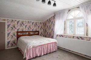 a bedroom with a bed and a window at Maalaishuvila Wanha Virkailija Iittala in Hämeenlinna