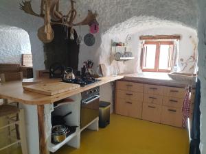cocina con encimera y fogones horno superior en Creatively designed CaveHouse with jacuzzi, en Gorafe