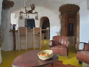 sala de estar con mesa y sillas y cocina en Creatively designed CaveHouse with jacuzzi, en Gorafe