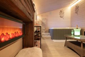 a room with a fireplace and a table and a tub at B&B 't Motjeshof in Tielt