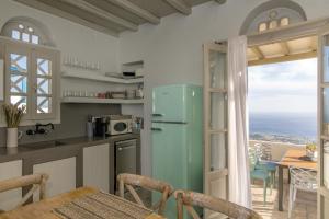 a kitchen and dining room with a view of the ocean at Apopsis Tinos View in Triandáros