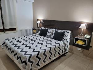 a bedroom with a large bed with a black and white comforter at Cerro Uritorco Hotel in Capilla del Monte