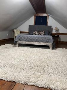 a bedroom with a bed and a white rug at Hanna’s Cottage-Downtown Hermann in Hermann